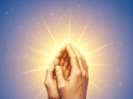 Hands praying with glowing light.